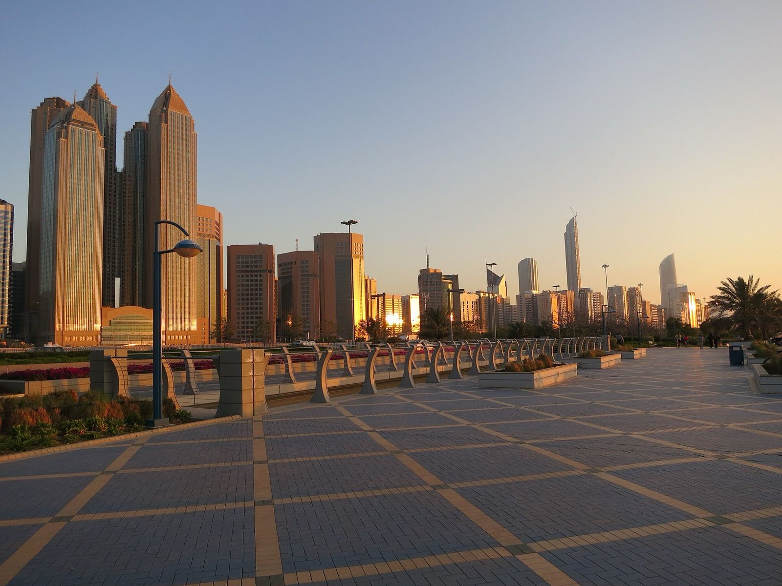 Abu Dhabi Corniche promenade and city towers at golden hour