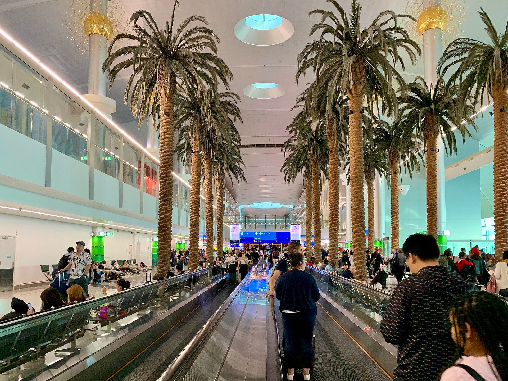 Palm lined concourse with moving walkways inside Terminal 3 at Dubai International Airport