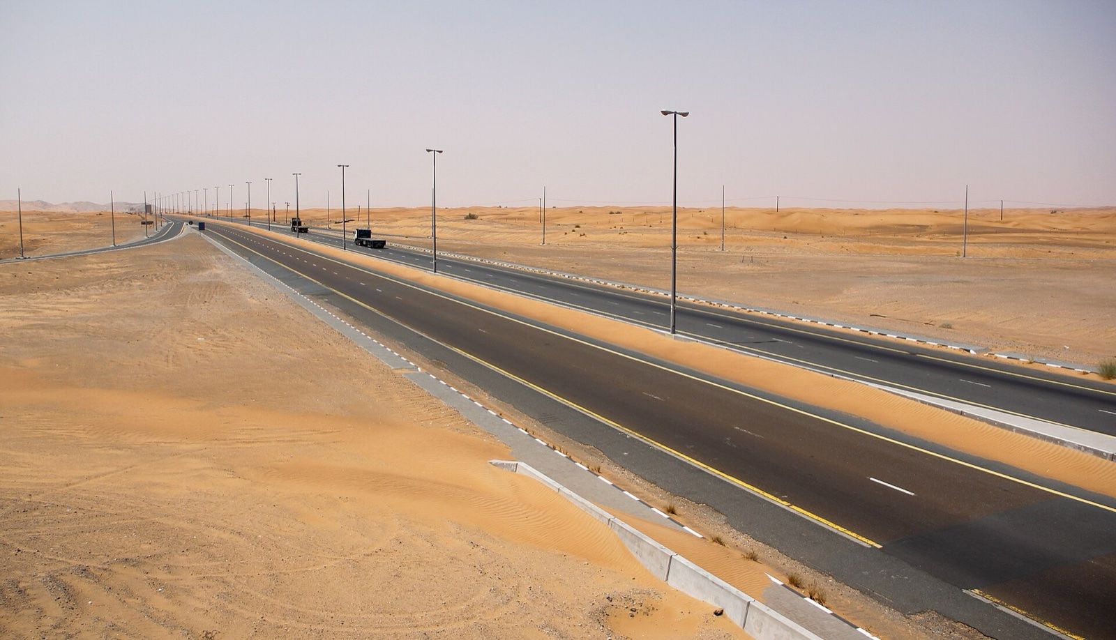 Divided highway crossing red desert sand in the emirate of Sharjah, UAE