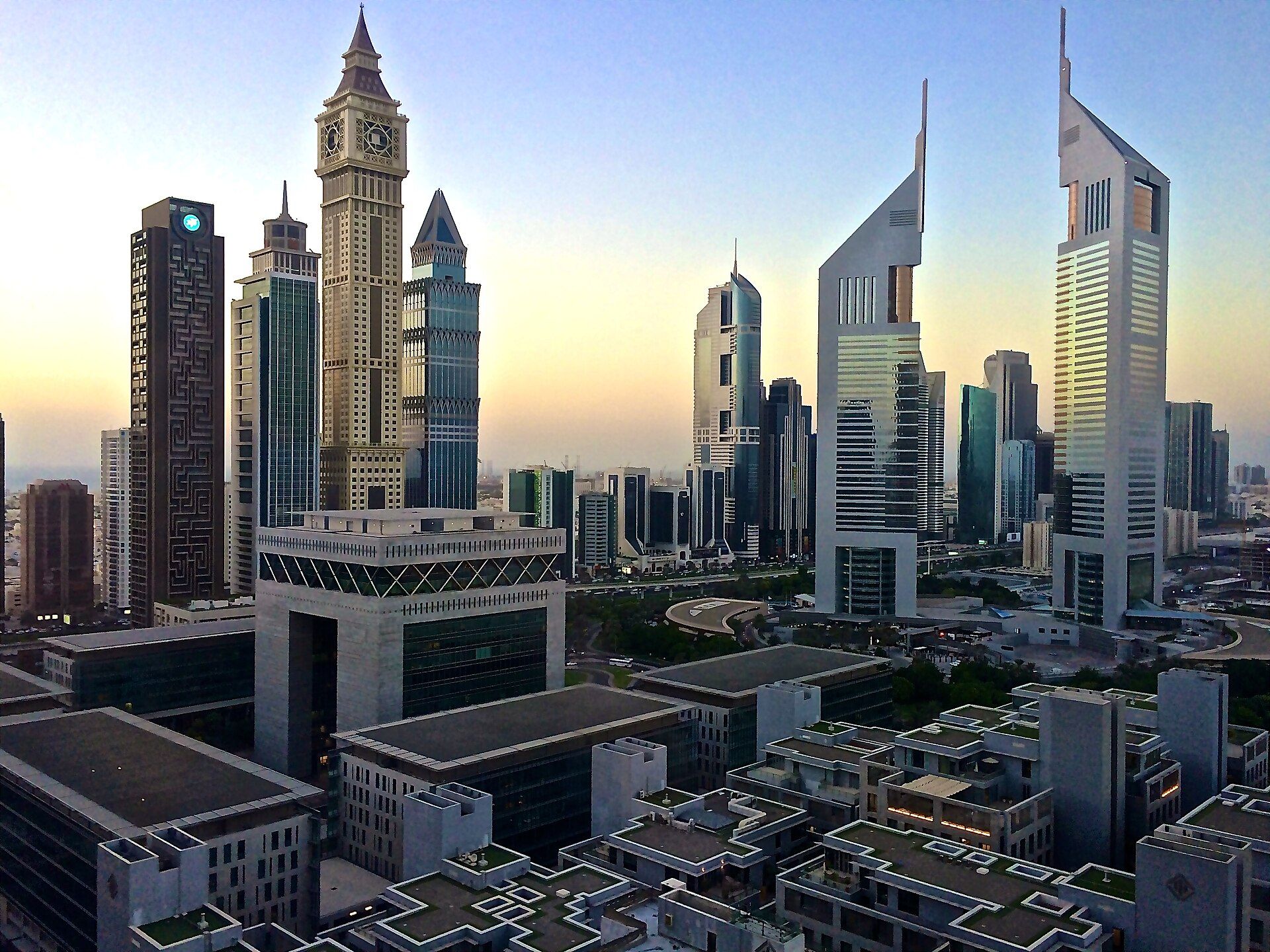 Emirates Towers and DIFC office towers in Dubai at dawn, with The Gate building in front