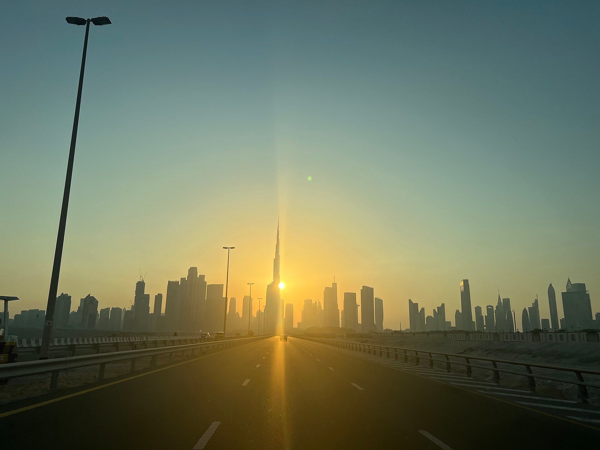 Highway leading toward the Dubai skyline and Burj Khalifa at sunset