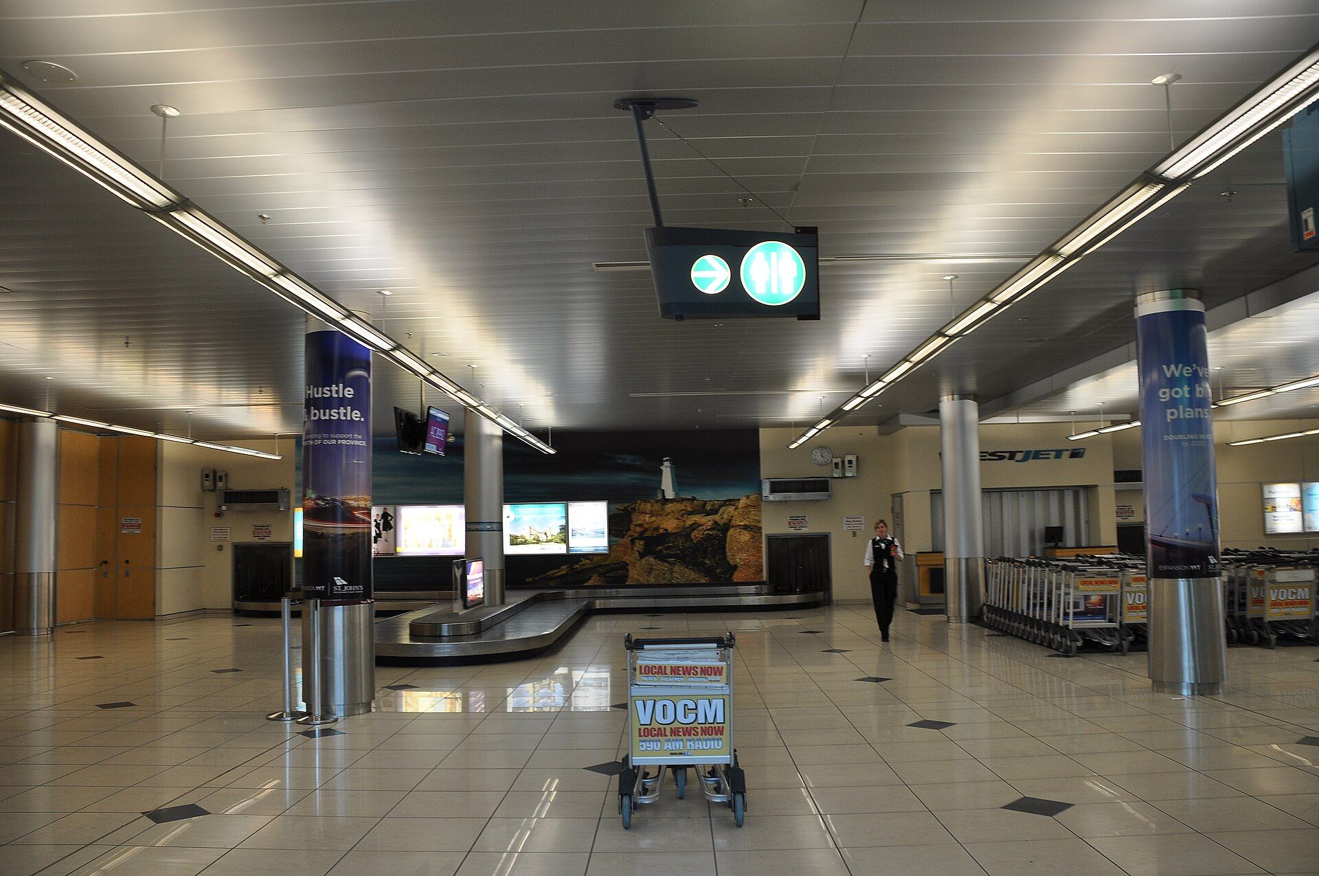 Baggage claim belts and luggage trolleys in a quiet airport arrivals hall